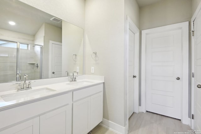 bathroom featuring vanity, wood-type flooring, and walk in shower