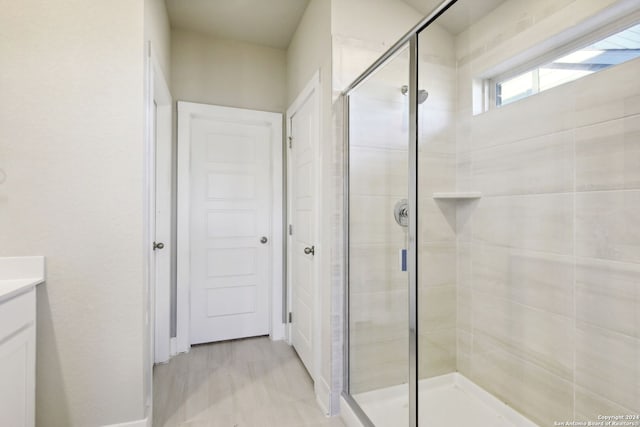 bathroom featuring walk in shower and vanity