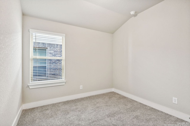 empty room with vaulted ceiling and carpet