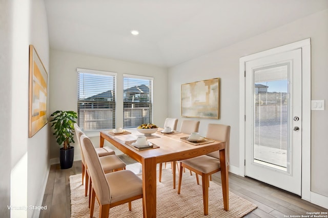 dining area with a wealth of natural light and light hardwood / wood-style flooring