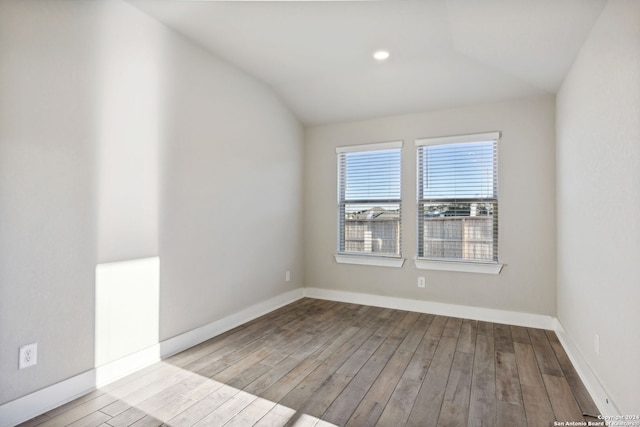 empty room featuring vaulted ceiling and light hardwood / wood-style flooring