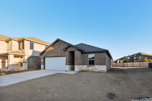 view of front of home with a garage and central air condition unit