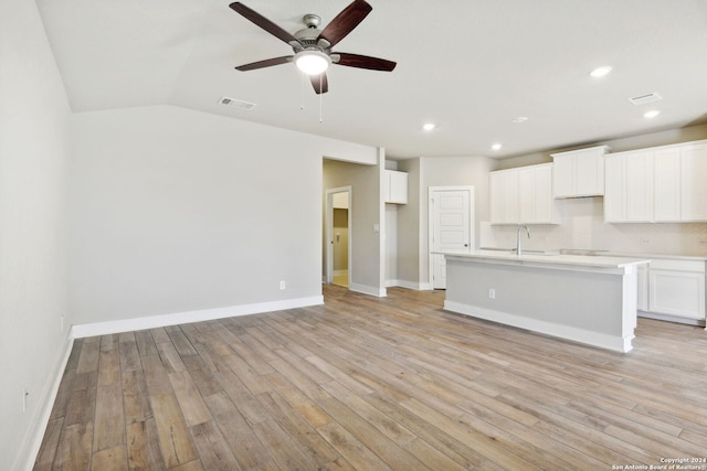 interior space featuring light wood-type flooring, ceiling fan, lofted ceiling, and sink