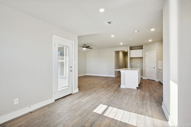 interior space with ceiling fan, light wood-type flooring, sink, and lofted ceiling