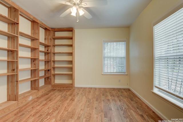 unfurnished room featuring a ceiling fan, light wood-style flooring, and baseboards