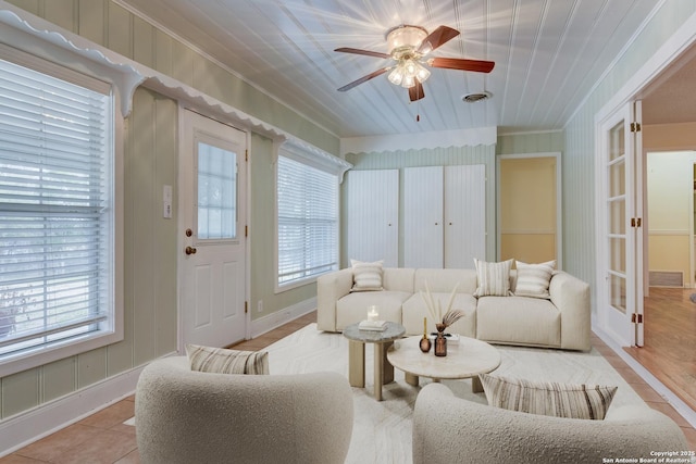 living area with ornamental molding, a healthy amount of sunlight, ceiling fan, and light tile patterned flooring