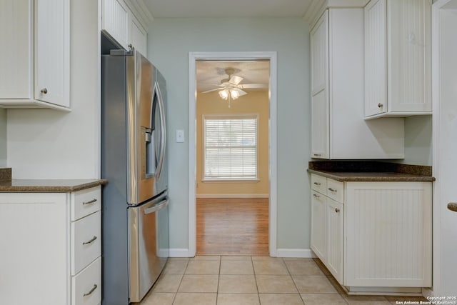 kitchen featuring dark countertops, white cabinets, stainless steel fridge with ice dispenser, and light tile patterned floors