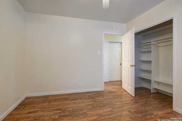 unfurnished bedroom featuring a closet, wood finished floors, and baseboards