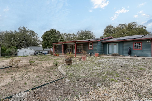 single story home with a patio, fence, and solar panels