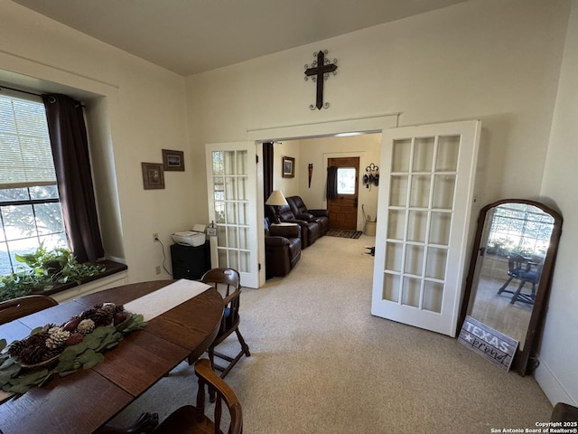 dining room with light carpet and french doors