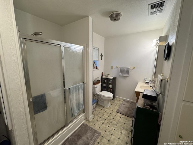 bathroom featuring an enclosed shower, vanity, and toilet