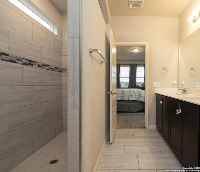 bathroom featuring a tile shower and vanity