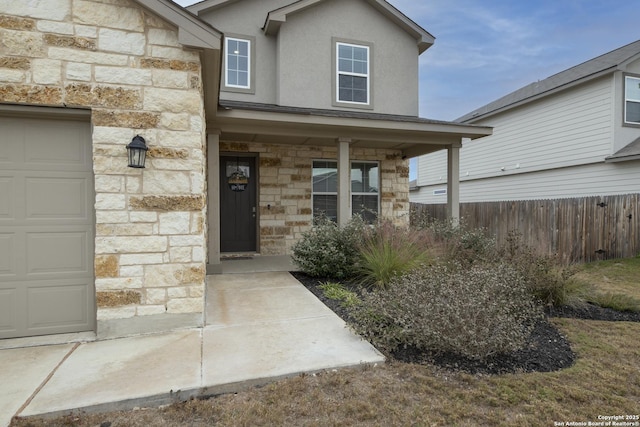 property entrance featuring covered porch and a garage