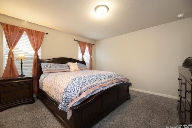 bedroom featuring dark carpet and multiple windows