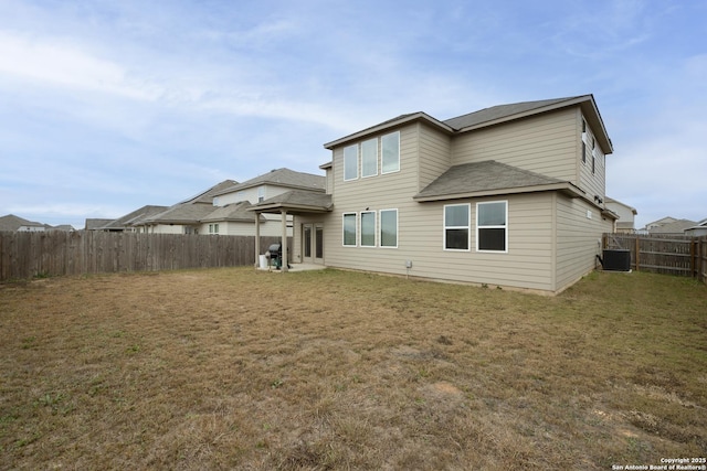 rear view of property featuring a lawn and central AC