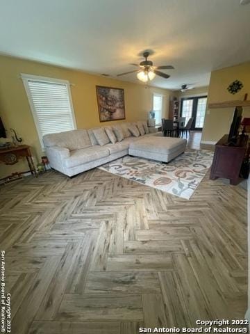 living room with ceiling fan and parquet flooring