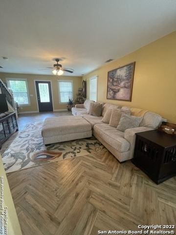 living room featuring ceiling fan and parquet flooring