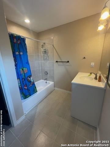 bathroom with tile patterned floors, vanity, and shower / tub combo