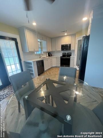 kitchen with sink, white cabinetry, and black appliances