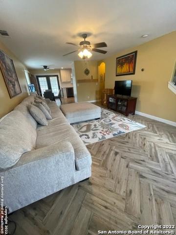 living room with ceiling fan and parquet floors