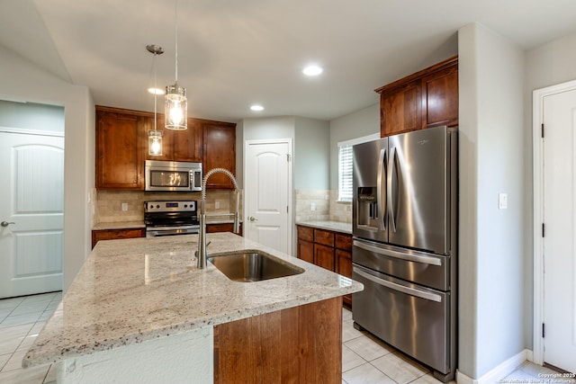 kitchen with stainless steel appliances, sink, tasteful backsplash, and a kitchen island with sink