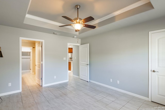 unfurnished bedroom featuring a raised ceiling, light tile patterned floors, ceiling fan, and ornamental molding