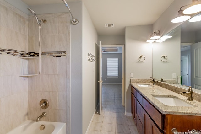 bathroom featuring tiled shower / bath combo, vanity, and tile patterned flooring