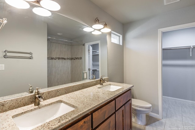 bathroom with tile patterned floors, vanity, toilet, and walk in shower