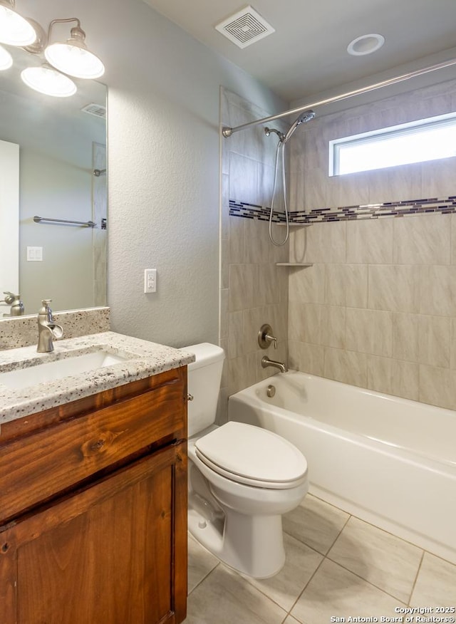 full bathroom featuring toilet, vanity, tiled shower / bath, and tile patterned flooring