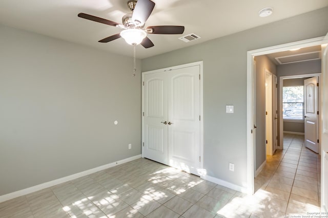 unfurnished bedroom with ceiling fan, light tile patterned floors, and a closet