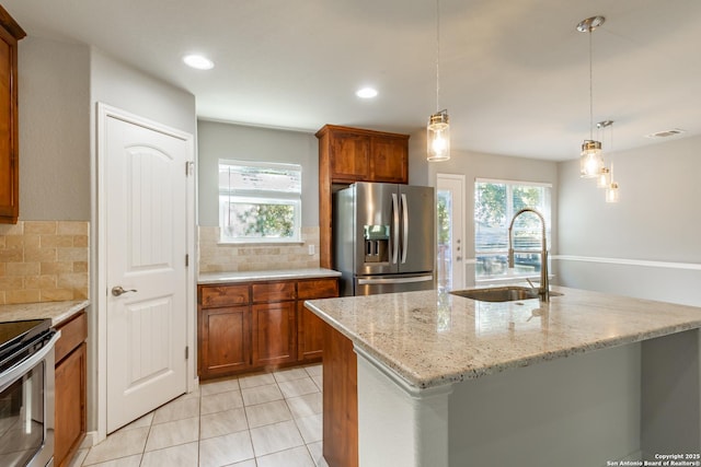 kitchen featuring light stone counters, sink, backsplash, and stainless steel appliances