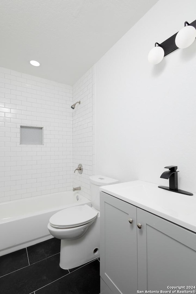 bathroom with toilet, vanity, and tile patterned floors