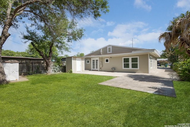 back of property with a lawn, french doors, and a patio