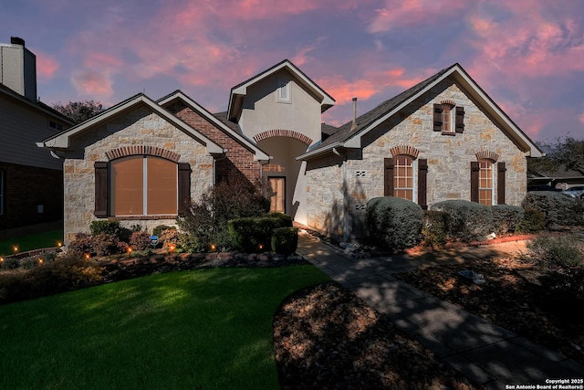 french country style house featuring a lawn