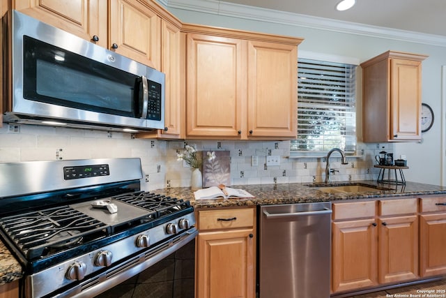 kitchen with appliances with stainless steel finishes, sink, backsplash, dark stone counters, and ornamental molding