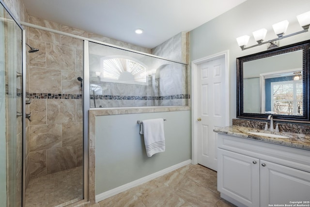 bathroom with vanity, an enclosed shower, and a healthy amount of sunlight