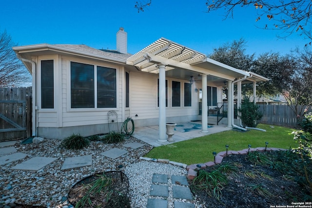 rear view of property featuring a yard, a patio area, and a pergola