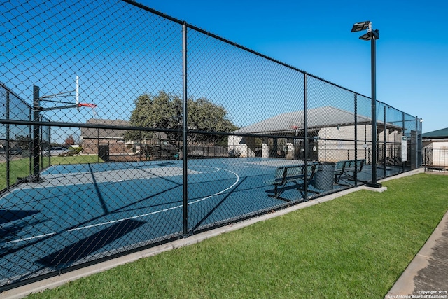 view of sport court with a lawn