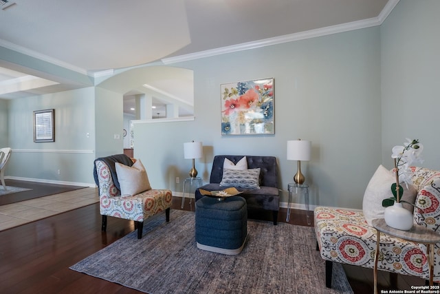 sitting room with ornamental molding and dark hardwood / wood-style flooring