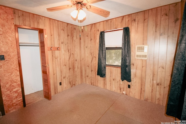 interior space featuring ceiling fan and wooden walls