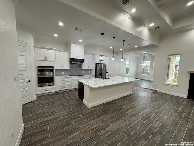 kitchen featuring a center island with sink, appliances with stainless steel finishes, sink, pendant lighting, and white cabinets