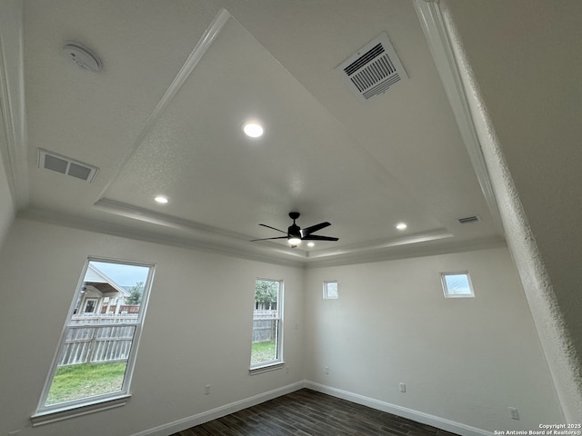 unfurnished room featuring ceiling fan, a raised ceiling, and dark hardwood / wood-style floors