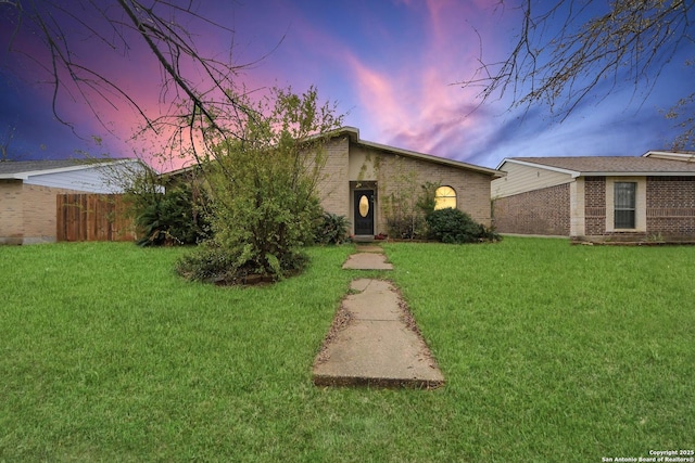 ranch-style home featuring a lawn