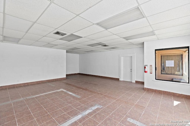 basement featuring tile patterned flooring and a drop ceiling