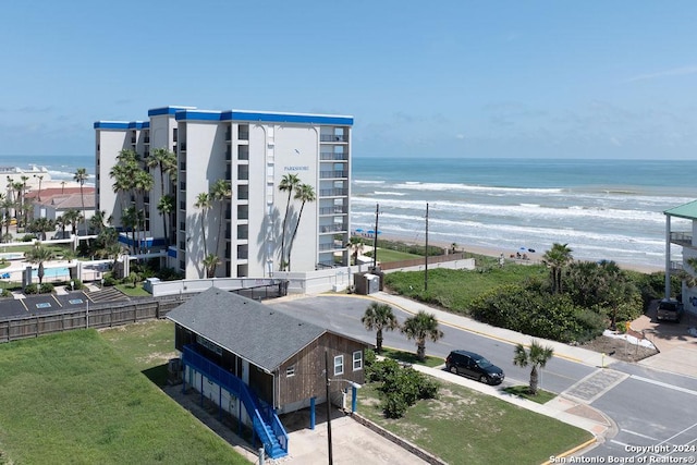 exterior space featuring a water view and a beach view