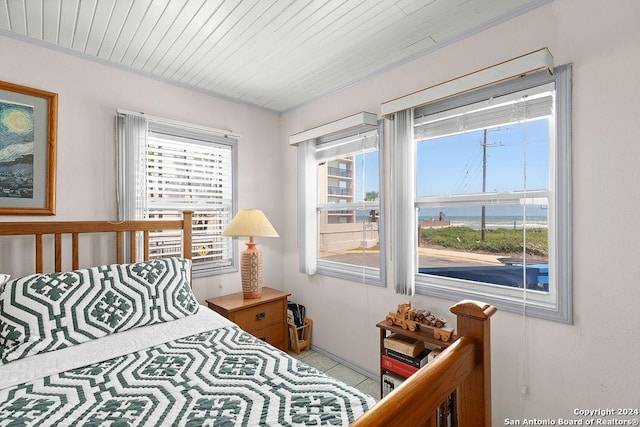 bedroom with light tile patterned floors and wooden ceiling