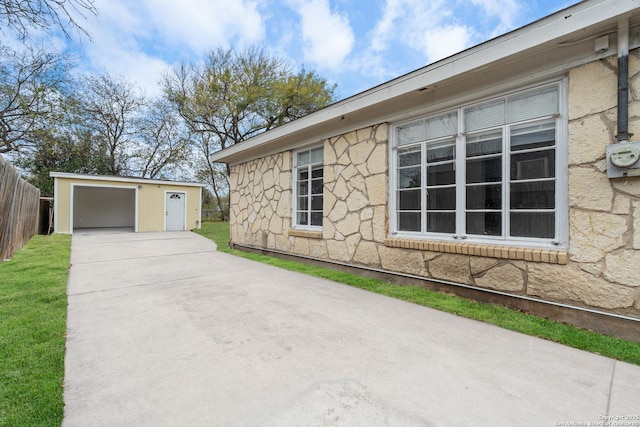 view of side of home featuring a garage and an outbuilding