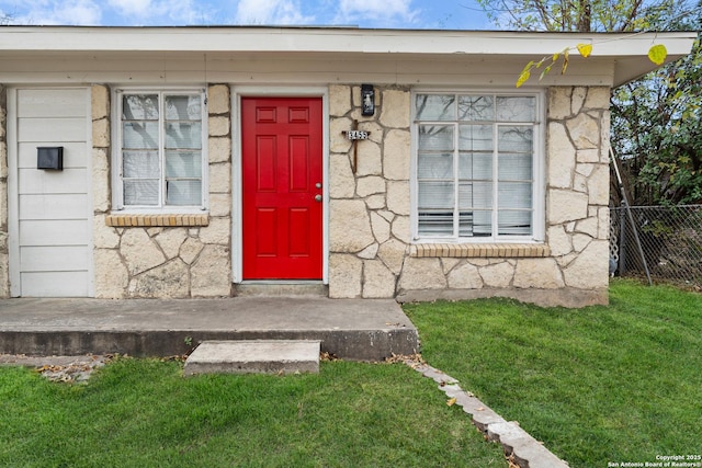 view of exterior entry with a yard