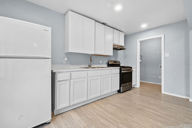 kitchen with white cabinetry, stainless steel range with gas stovetop, light wood-type flooring, white refrigerator, and sink