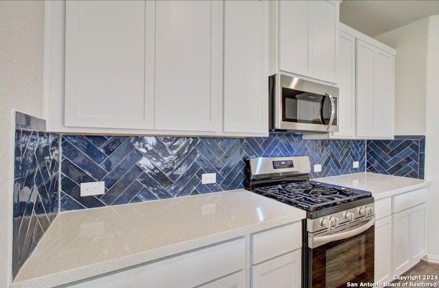 kitchen with decorative backsplash, white cabinetry, and appliances with stainless steel finishes